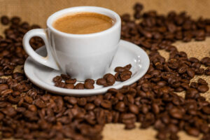 Café na xícara com grãos ao redor