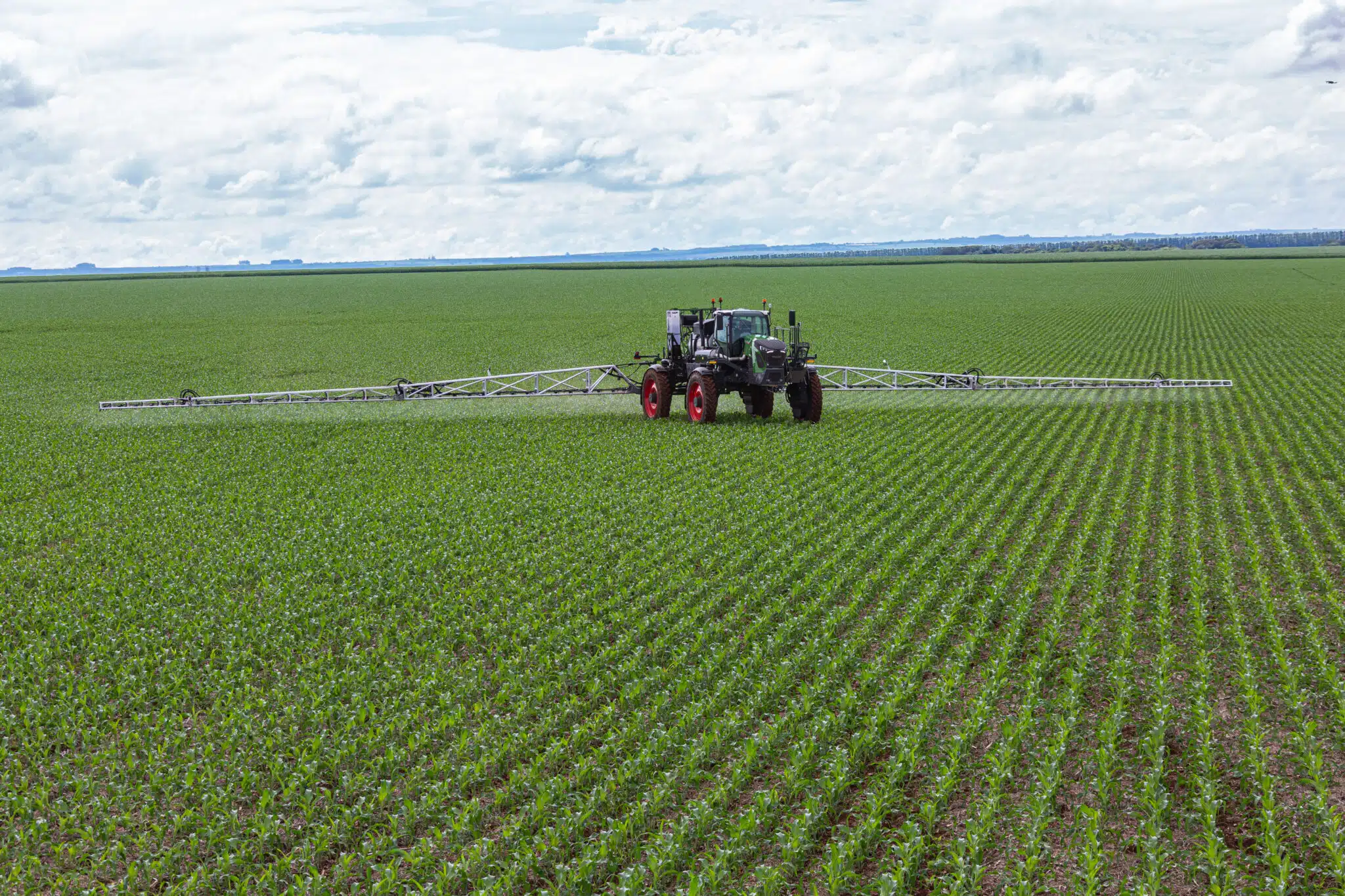 Trator pulverizando fertilizantes na plantação