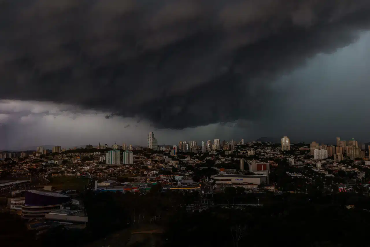 Nuvens escuras e carregadas avançam sobre uma área urbana do interior paulista, indicando a chegada de uma forte tempestade com potencial para chuva intensa e rajadas de vento.