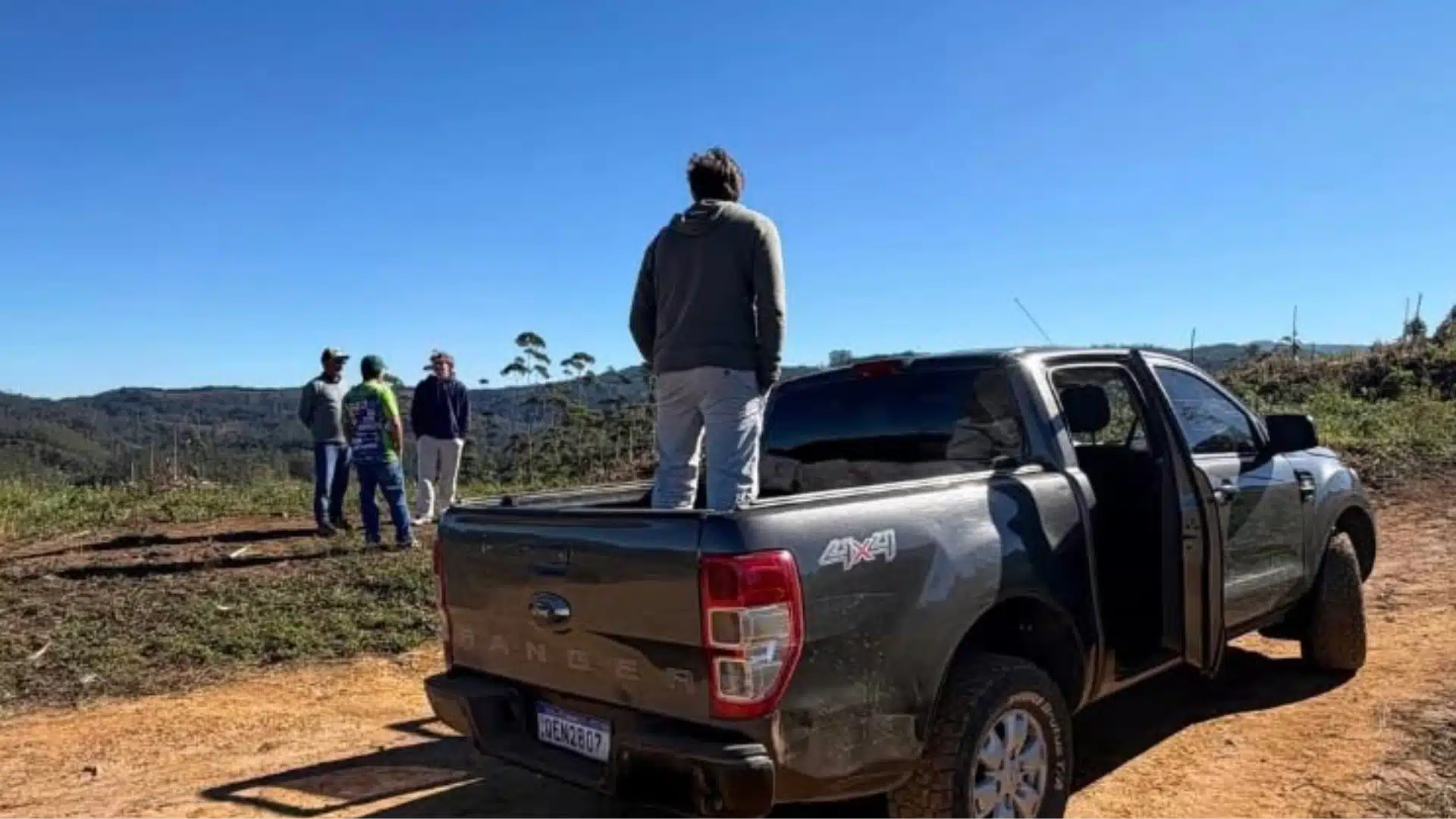 Luciano Huck em cima de uma caminhonete olhando a fazenda
