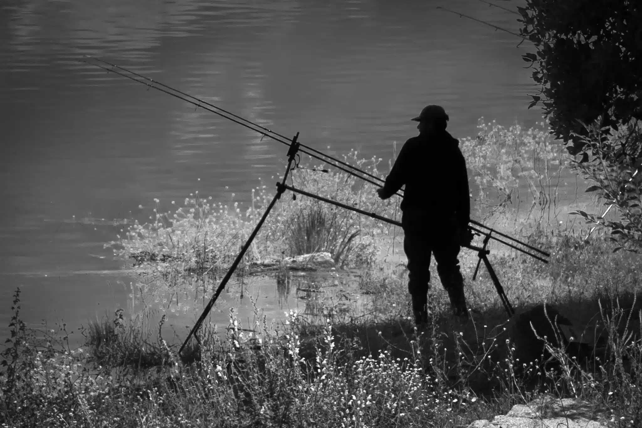 Foto preto e branca de pescador à beira do rio