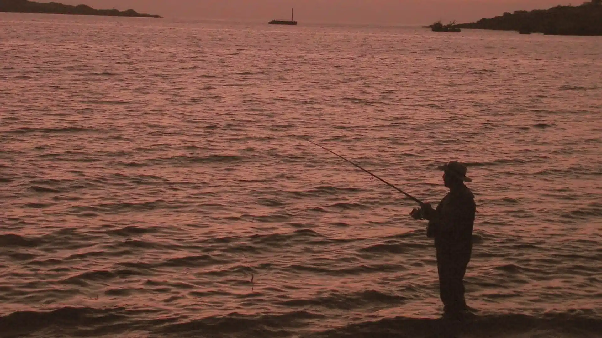 Pescador com vara de pesca à beira do lago