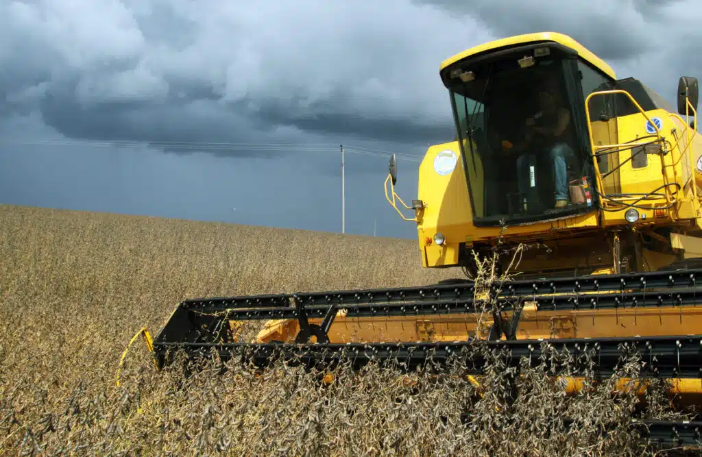 Máquina agrícola trabalha no campo antes da chegada da chuva, que pode interromper o plantio e a colheita.